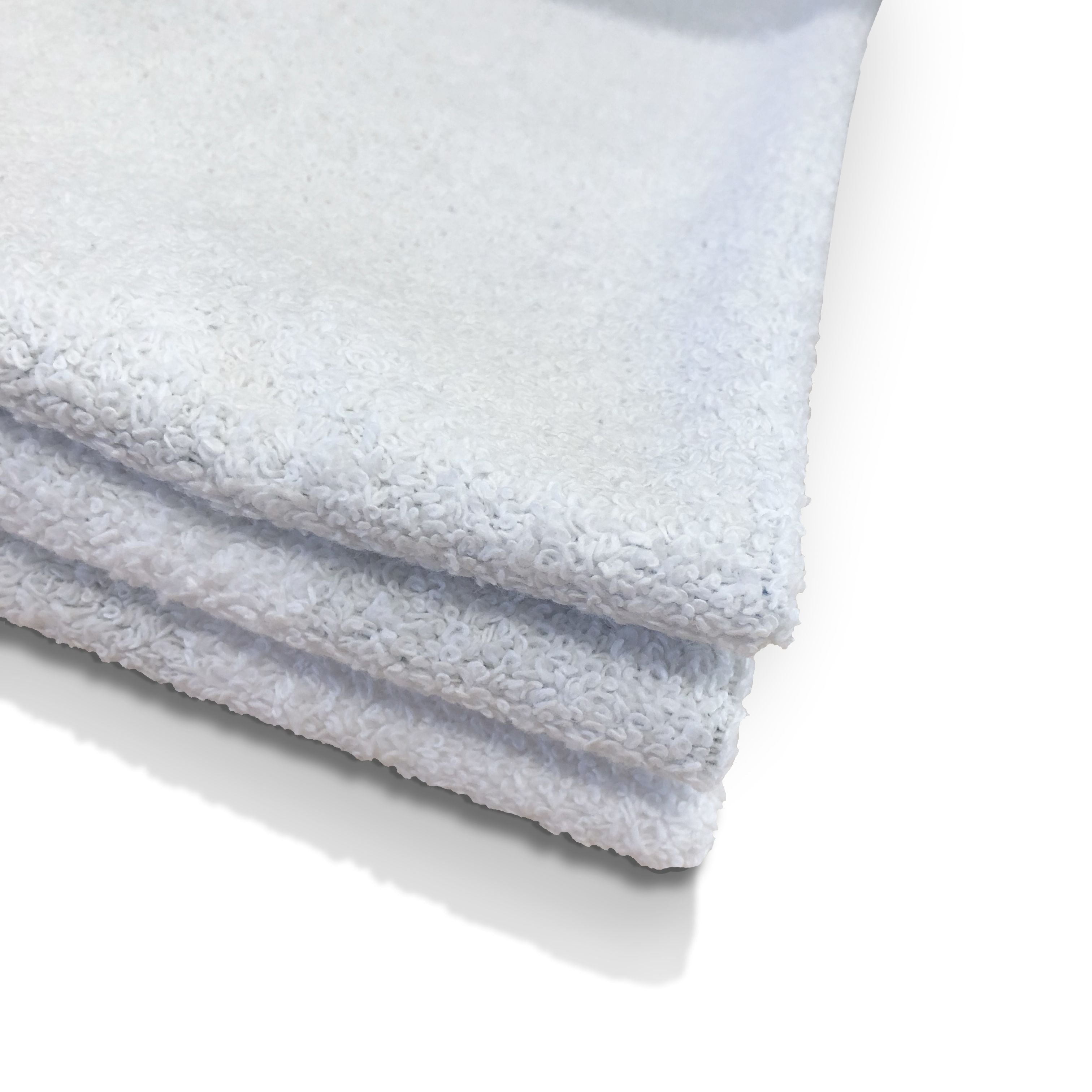 Triple-layered plush white towels stacked, ideal for luxury baths.